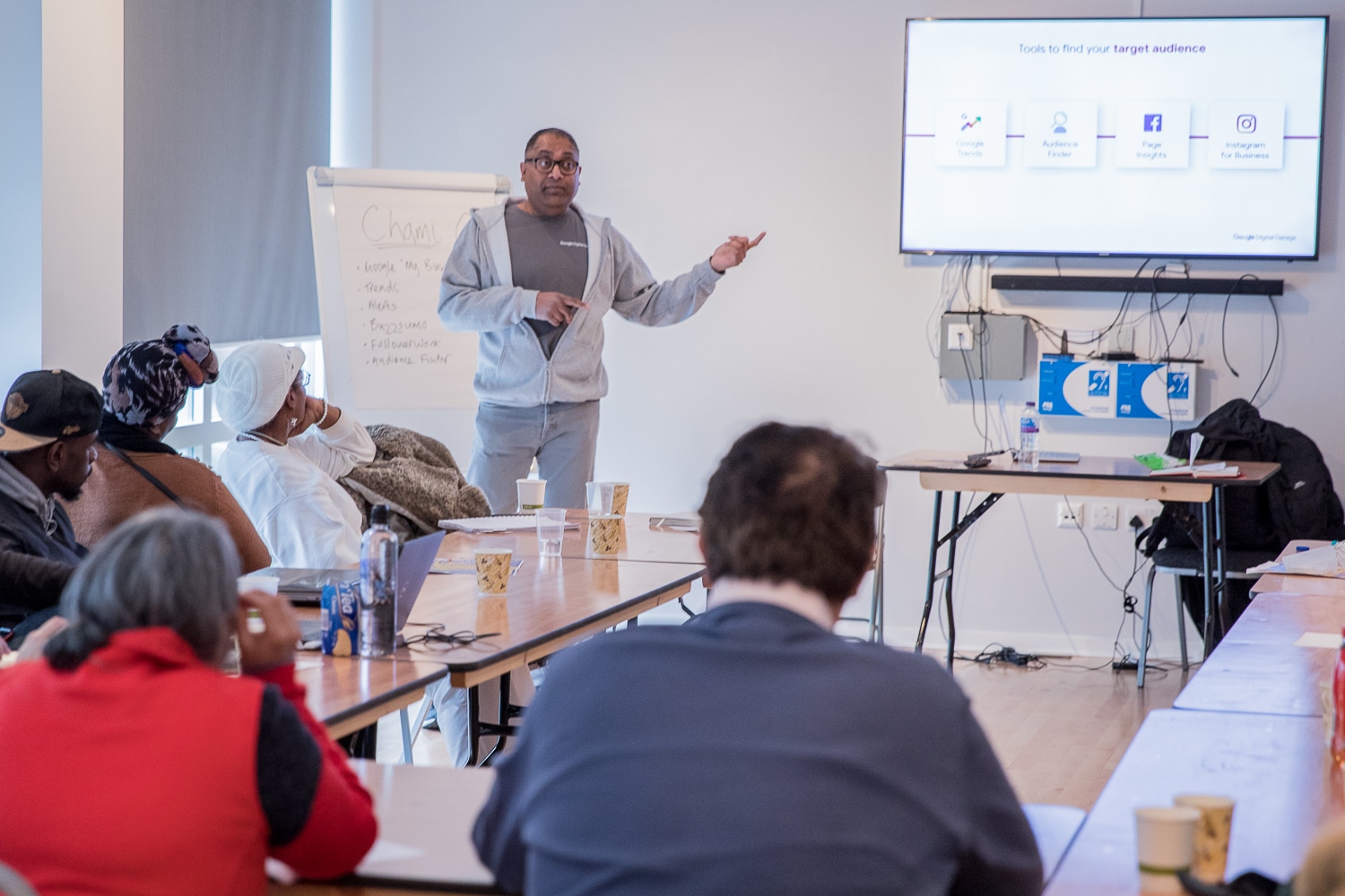 Man pointing to a screen while presenting a training course.