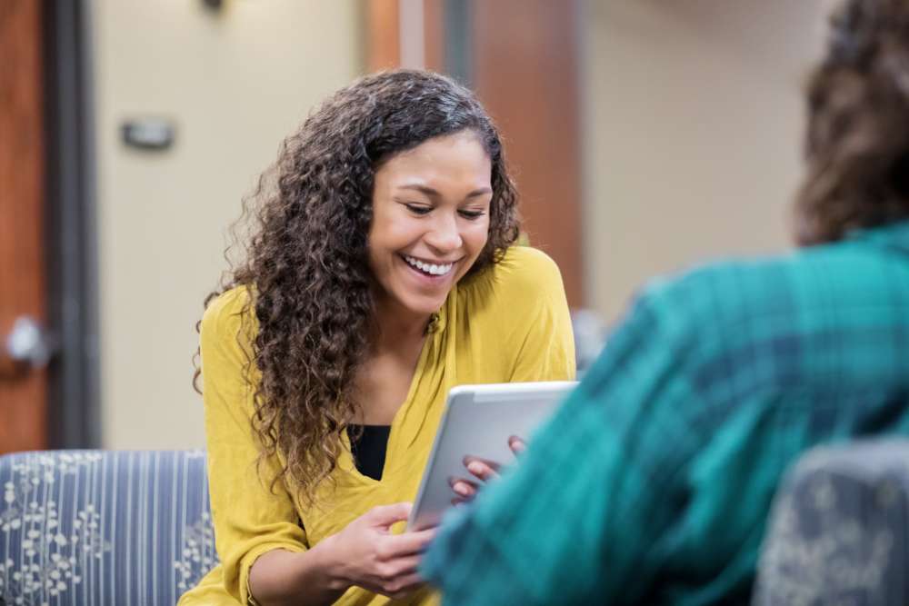 Photo of woman smiling and holding a clipboard.